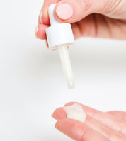 Hand holding a white dropper with a Foxtail Beauty All Rounder Serum all in one face serum for dry skin