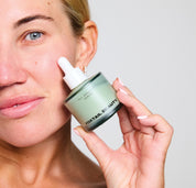 Person applying a product from a Foxtail Beauty jar to their face.