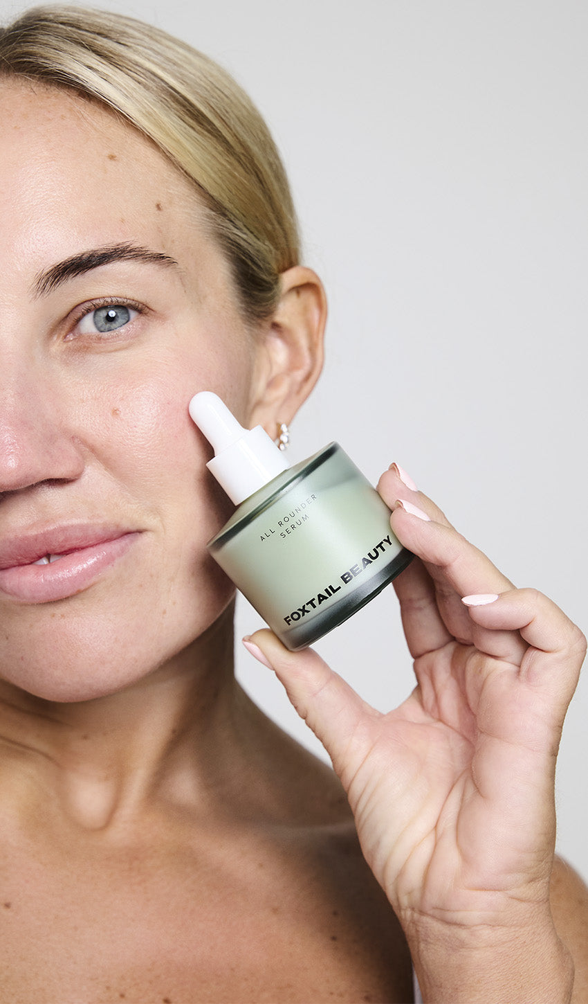 Woman holding Foxtail Beauty All Rounder Serum — clean girl skincare for confident natural skin and effortless glow